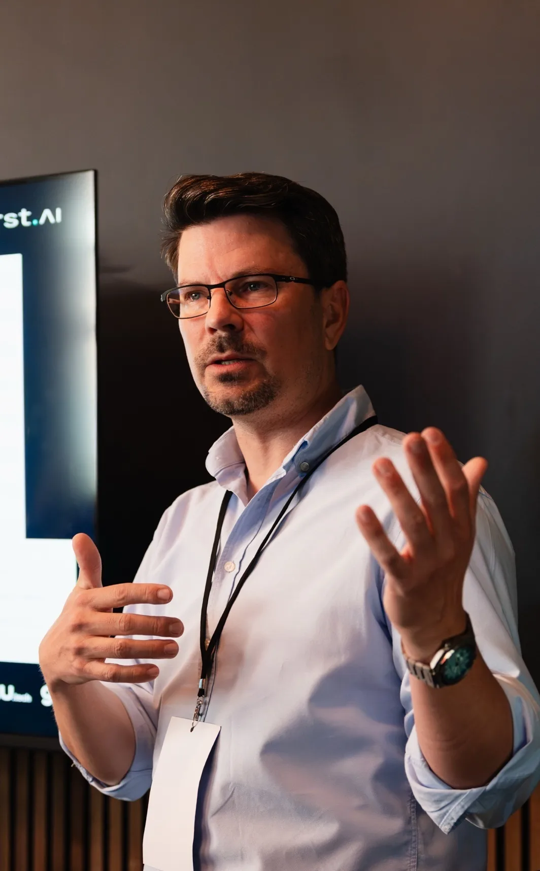 Florian Fürst spricht beim Berlin AI Day 2026 vor einem Bildschirm mit dem fuerst.ai-Logo